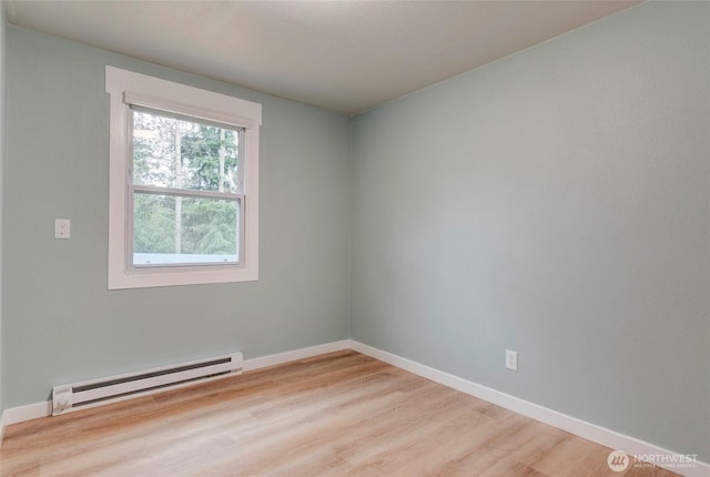 unfurnished room featuring baseboards, wood finished floors, and a baseboard radiator