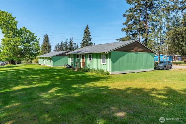 exterior space featuring a lawn and roof with shingles