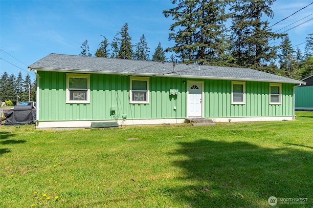 view of front of property featuring board and batten siding, a shingled roof, and a front lawn
