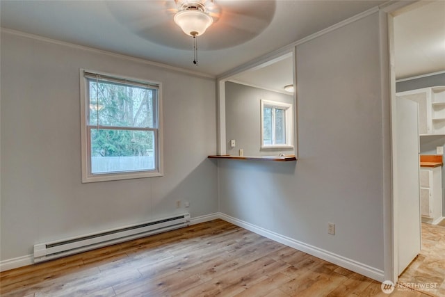 spare room featuring crown molding, a ceiling fan, wood finished floors, baseboards, and a baseboard radiator