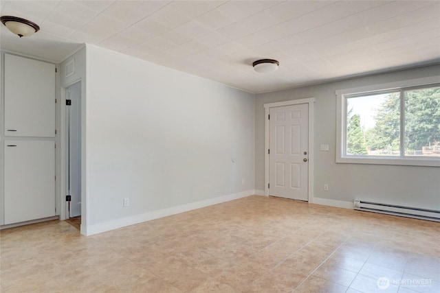 unfurnished room with baseboards, a baseboard heating unit, and light tile patterned floors