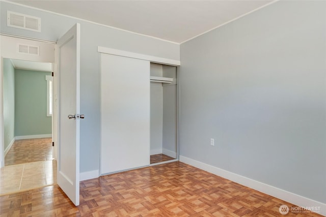 unfurnished bedroom featuring baseboards, visible vents, and a closet