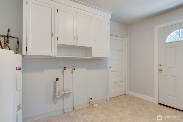 washroom with baseboards, tile patterned floors, cabinet space, and electric water heater