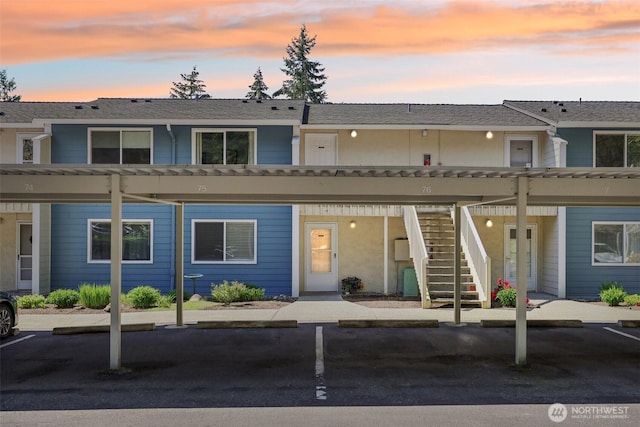 view of front of property with stairway and covered parking