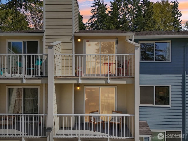 rear view of property with a chimney and a balcony