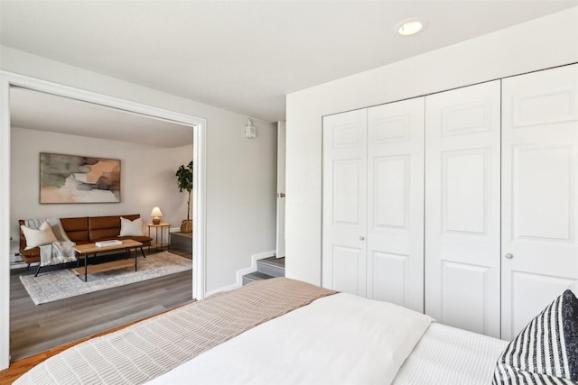 bedroom with wood finished floors, recessed lighting, and a closet