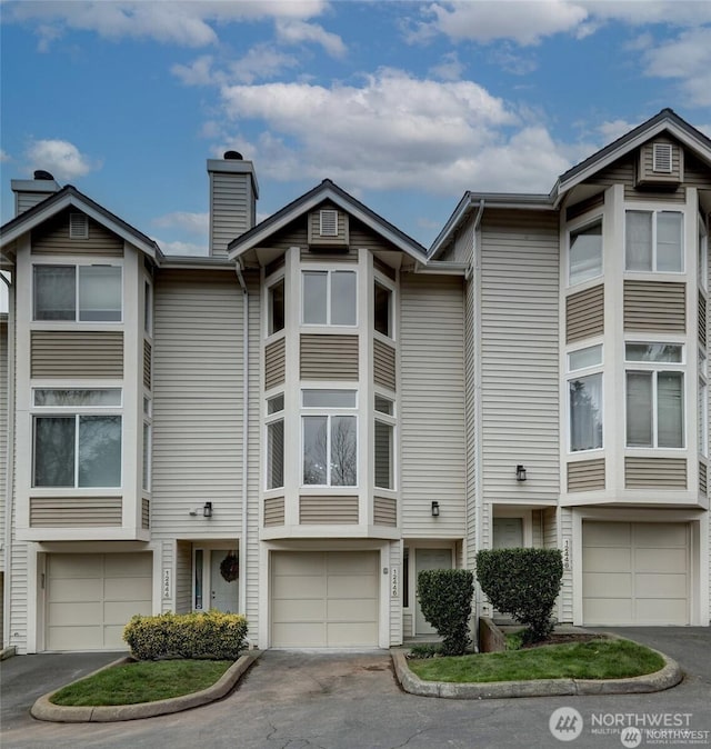 12446 NE 7th Pl, Bellevue, WA 98005 - townhome / multi-family property with a garage, driveway, and a chimney