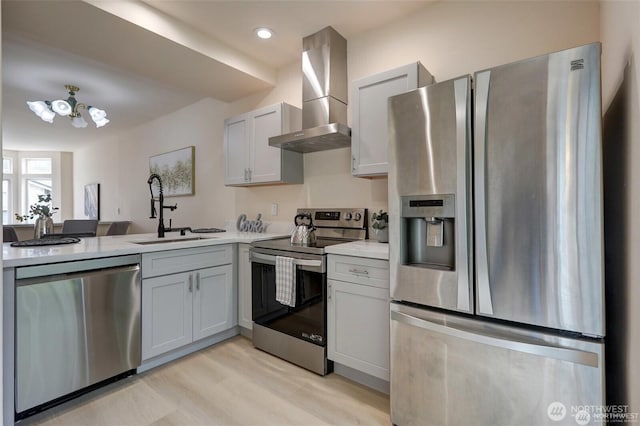 12446 NE 7th Pl, Bellevue, WA 98005 - kitchen with wall chimney range hood, light countertops, a sink, stainless steel appliances, and light wood finished floors