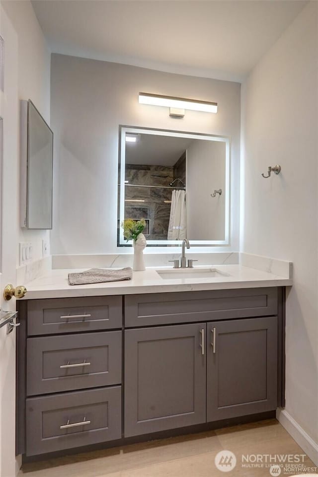 12446 NE 7th Pl, Bellevue, WA 98005 - bathroom featuring curtained shower, wood finished floors, vanity, and baseboards