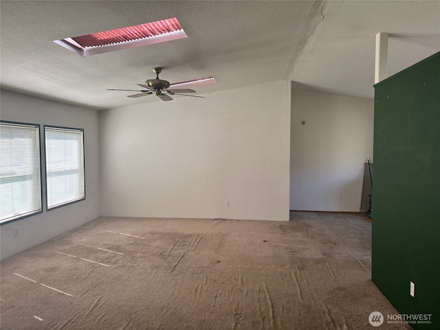 carpeted empty room with lofted ceiling, a textured ceiling, and ceiling fan