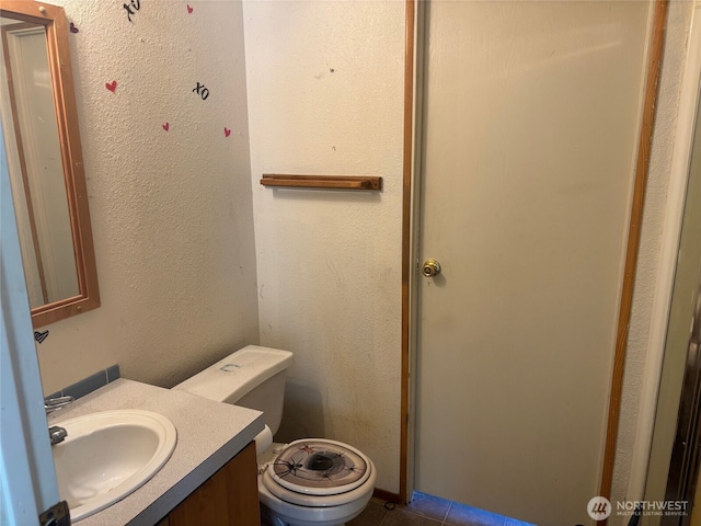bathroom with vanity, tile patterned flooring, and toilet