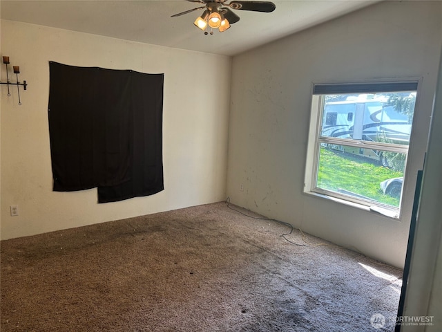 carpeted spare room featuring ceiling fan
