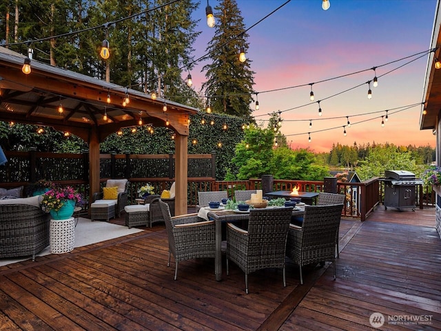 wooden terrace featuring a gazebo, a grill, outdoor dining space, and an outdoor living space with a fire pit