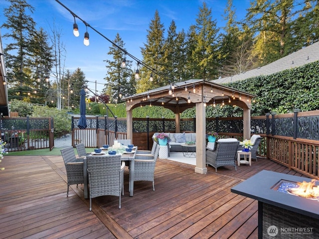 wooden terrace featuring a gazebo, an outdoor living space with a fire pit, outdoor dining area, and fence