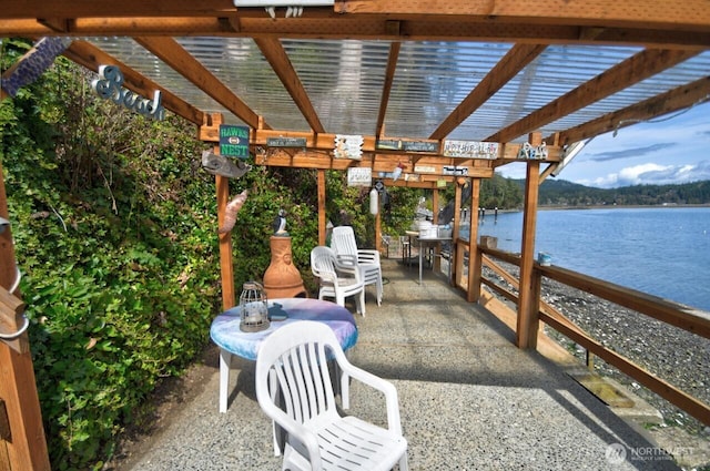 view of patio / terrace with a pergola and a water view