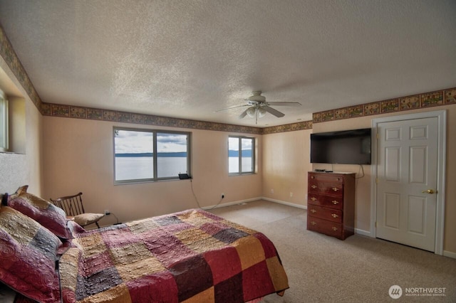 bedroom with a textured ceiling, carpet flooring, and baseboards