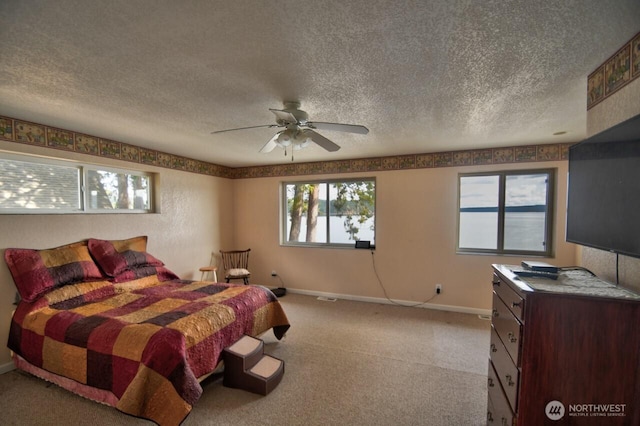 bedroom featuring baseboards, ceiling fan, light colored carpet, and a textured ceiling