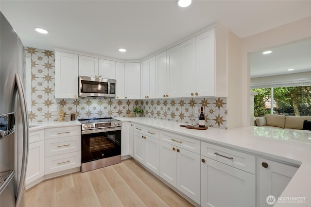 19010 12th Ave NE, Shoreline, WA 98155 - kitchen with stainless steel appliances, white cabinets, backsplash, light wood finished floors, and recessed lighting