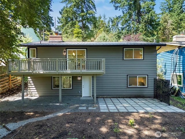 19010 12th Ave NE, Shoreline, WA 98155 - rear view of house with a chimney, a patio area, a metal roof, and a wooden deck
