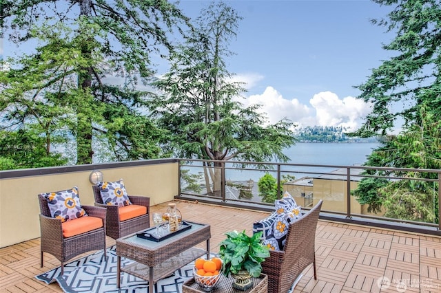 balcony with a water view and an outdoor living space