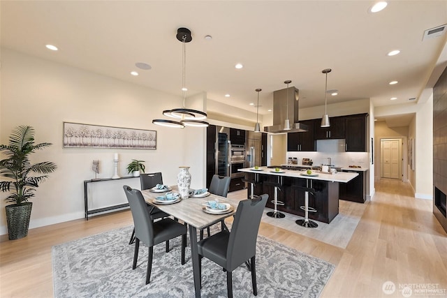 dining room featuring recessed lighting, light wood-style floors, baseboards, and visible vents