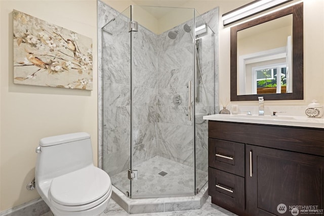 bathroom with toilet, a shower stall, and vanity