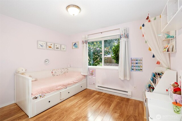 bedroom featuring baseboard heating and light wood-style flooring