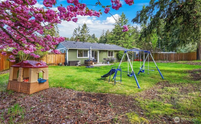 back of property featuring a playground, a patio, a lawn, and a fenced backyard