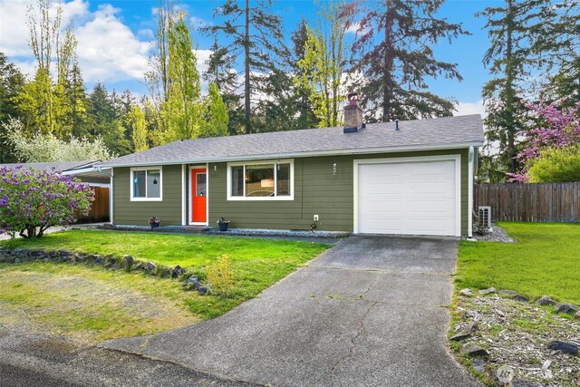 ranch-style home featuring a garage, fence, a chimney, and a front lawn