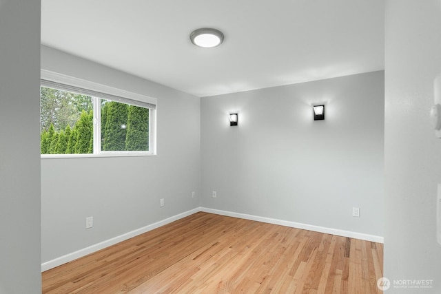 unfurnished room featuring baseboards and light wood-style floors