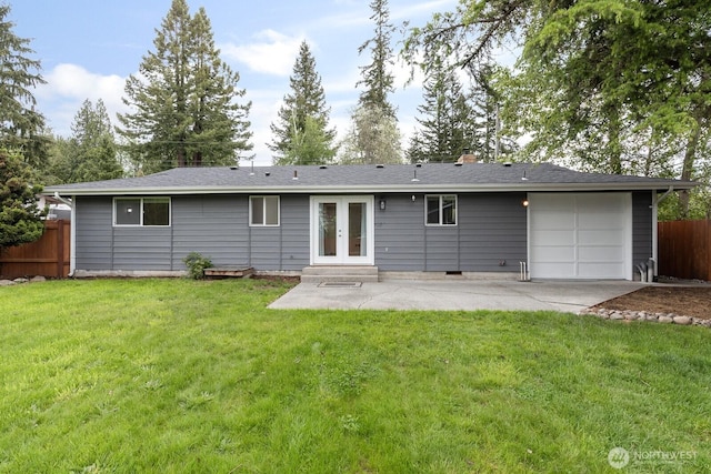back of property featuring french doors, a patio area, a garage, a chimney, and driveway