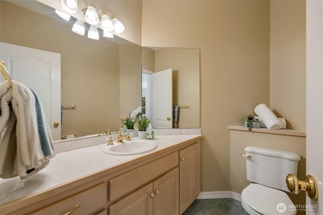 bathroom with toilet, tile patterned floors, vanity, and baseboards