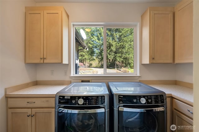 washroom featuring cabinet space and independent washer and dryer