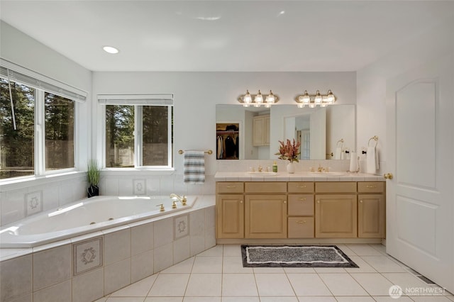 full bathroom with a bath, a sink, and tile patterned flooring