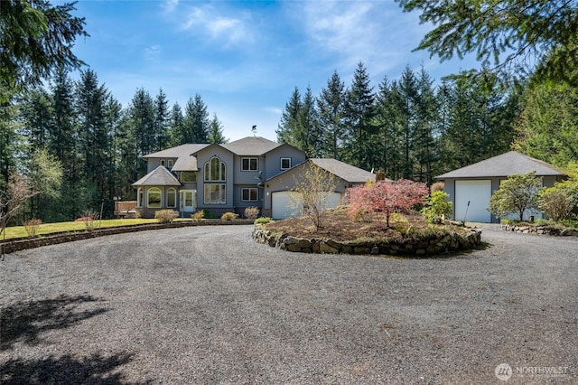 view of front facade with an attached garage and gravel driveway