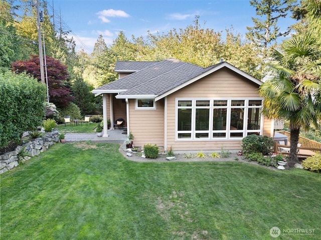 14407 Goodrich Dr NW, Gig Harbor, WA 98329 - rear view of property featuring roof with shingles, a patio, and a lawn