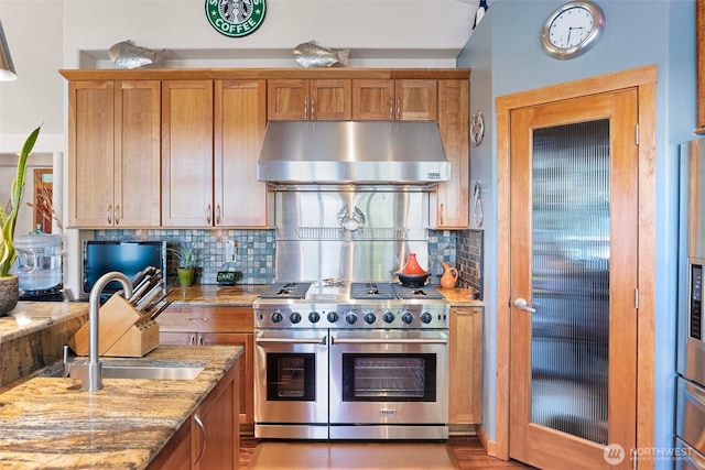 14407 Goodrich Dr NW, Gig Harbor, WA 98329 - kitchen with light stone counters, a sink, exhaust hood, and range with two ovens