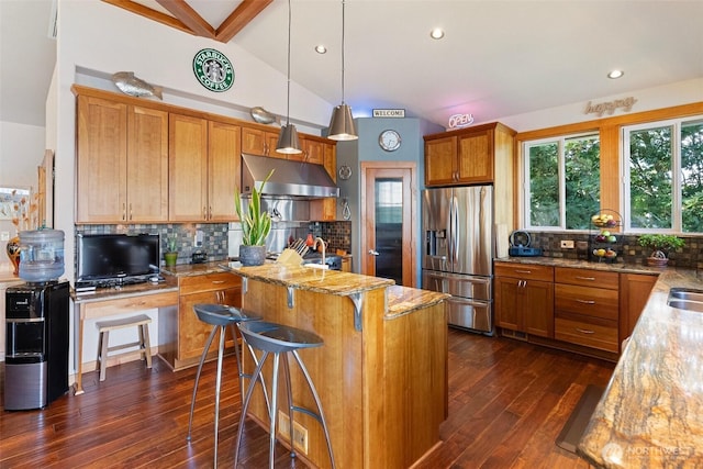 14407 Goodrich Dr NW, Gig Harbor, WA 98329 - kitchen featuring stainless steel fridge with ice dispenser, a center island, under cabinet range hood, backsplash, and lofted ceiling