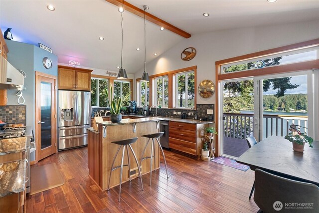 14407 Goodrich Dr NW, Gig Harbor, WA 98329 - kitchen featuring stainless steel fridge with ice dispenser, dark wood-style flooring, lofted ceiling with beams, backsplash, and brown cabinets