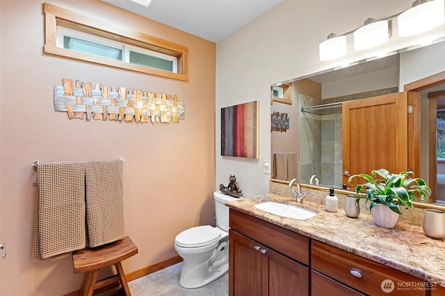 14407 Goodrich Dr NW, Gig Harbor, WA 98329 - bathroom featuring toilet, a tile shower, vanity, and baseboards