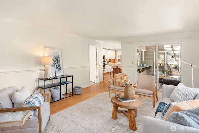 living room featuring light wood-type flooring and ornamental molding