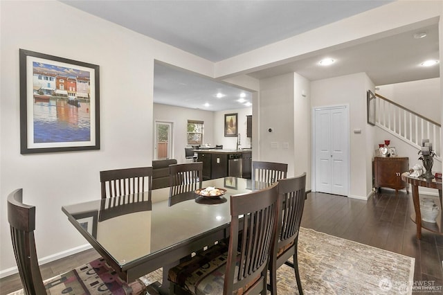 dining space featuring baseboards, wood finished floors, recessed lighting, and stairs