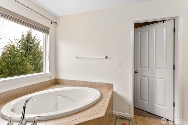 bathroom with a bath, a healthy amount of sunlight, and tile patterned flooring