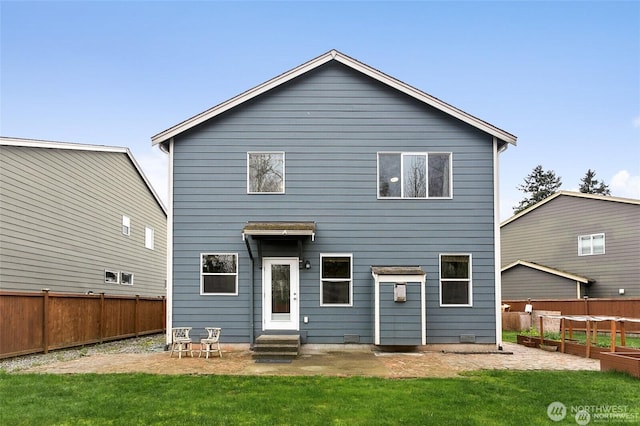 back of property featuring a yard, entry steps, and a fenced backyard