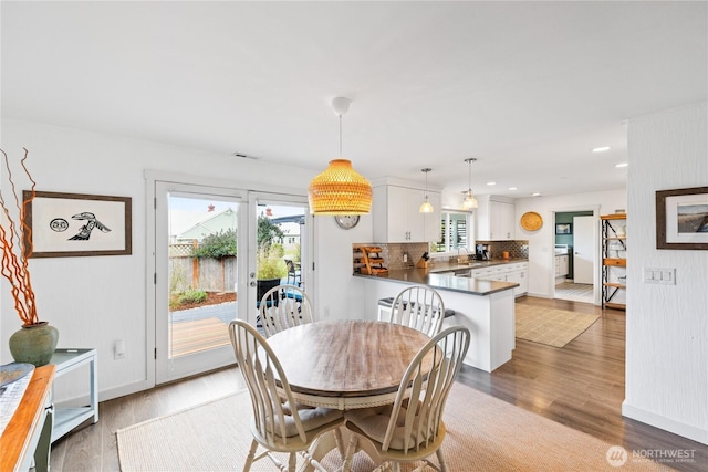 dining room featuring recessed lighting, light wood finished floors, baseboards, and a healthy amount of sunlight