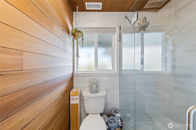 bathroom with toilet, a stall shower, wooden ceiling, and visible vents
