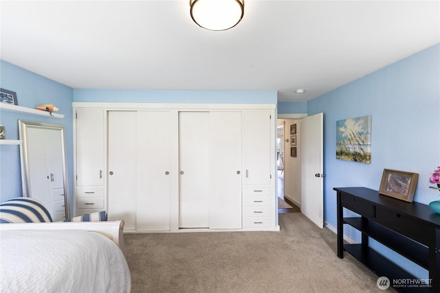 bedroom with a closet and light carpet