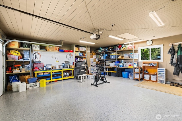 garage with wood ceiling, a garage door opener, and a workshop area