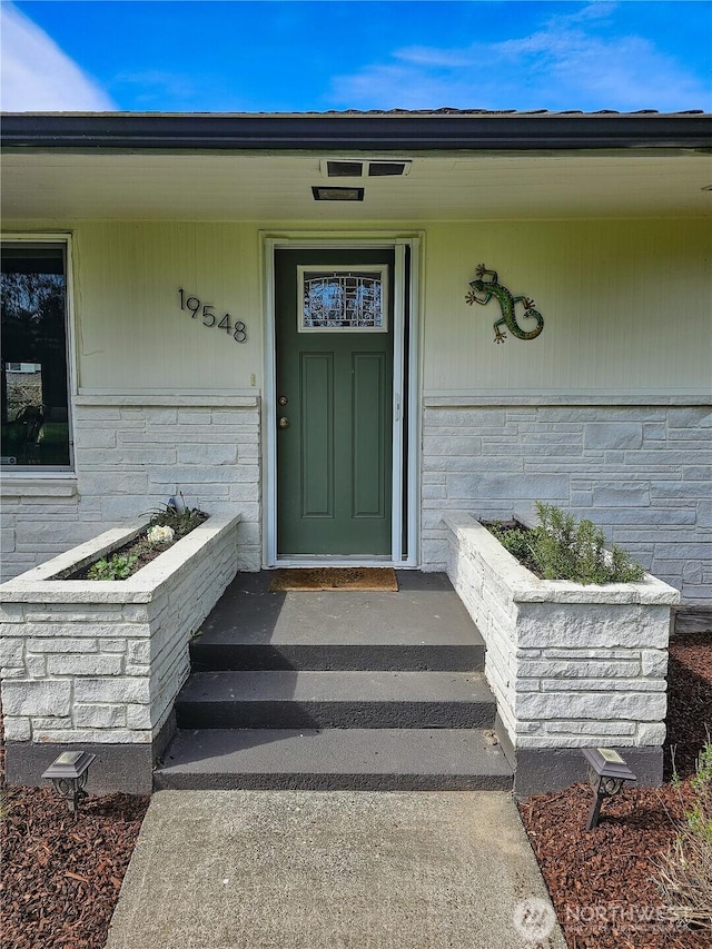 doorway to property featuring brick siding