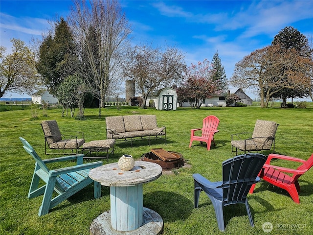 view of yard with a shed, a fire pit, and an outdoor structure